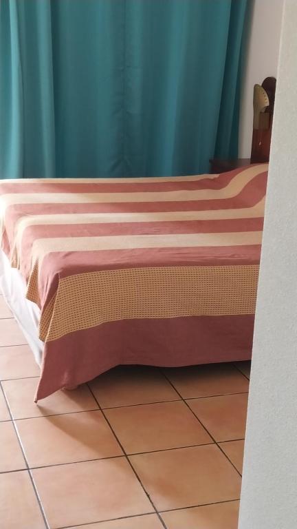 - un lit avec une couverture rouge et brune au sol dans l'établissement Studio Hibiscus, à Sainte-Anne
