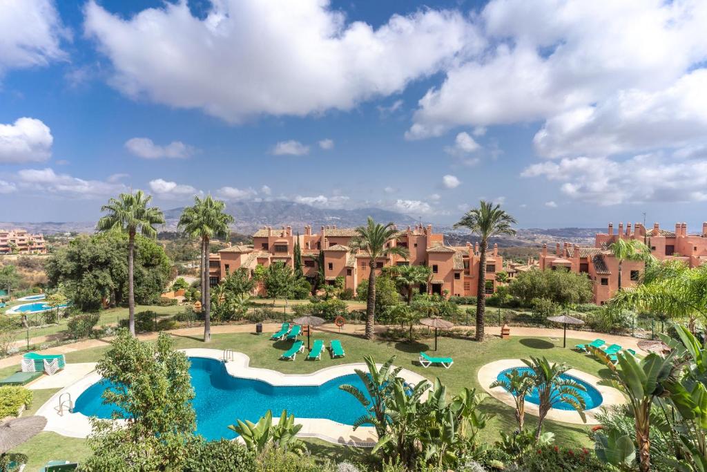 vista su un resort con 2 piscine e palme di El Soto de Marbella a Marbella