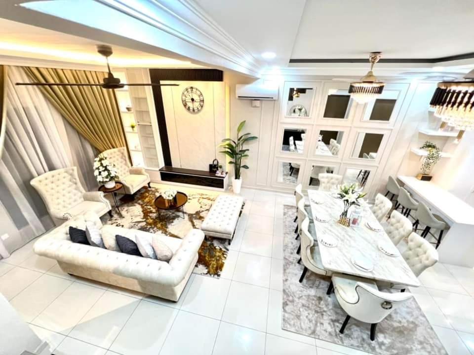 FARIDZ Homestay at Myra Saujana في Kampong Simpang Empat: غرفة معيشة بأثاث أبيض وطاولة