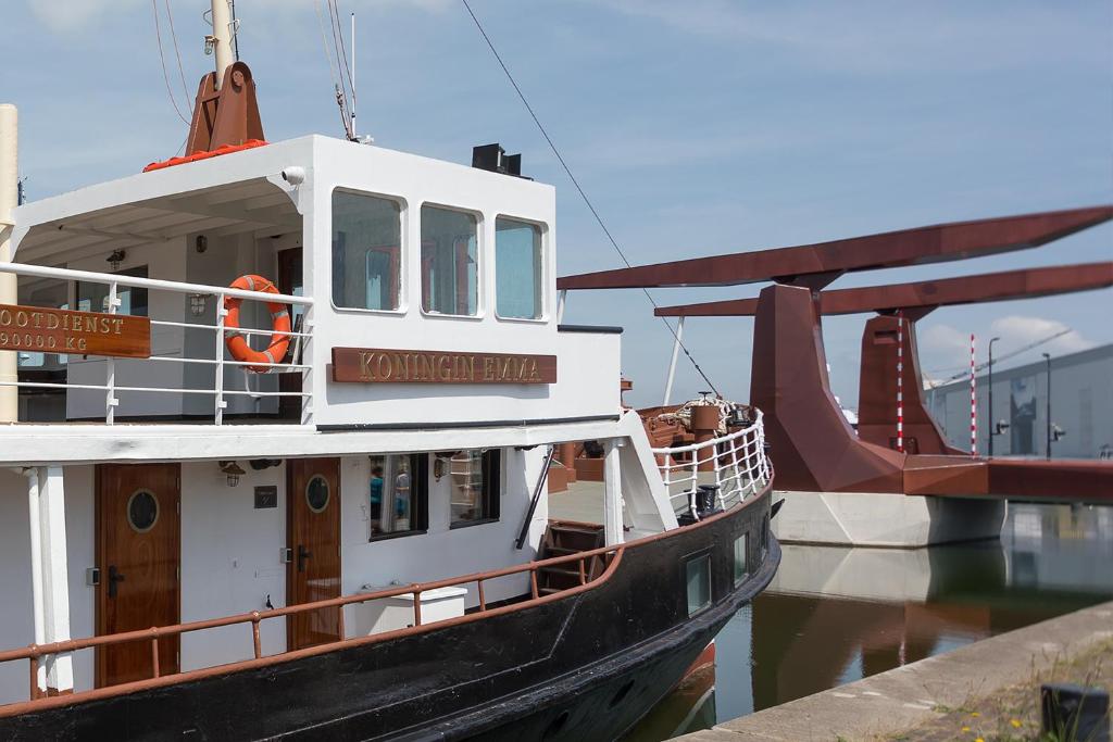 un bateau est amarré à un quai dans l'eau dans l'établissement Hotelboot Koningin Emma I Kloeg Collection, à Flessingue