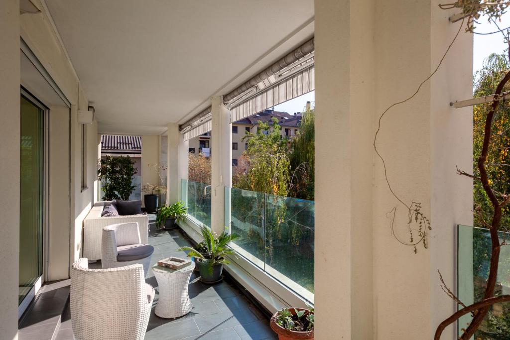 Luxury apartment with terrace - Forze Armate في ميلانو: شرفة فارغة مع نافذة كبيرة بها نباتات