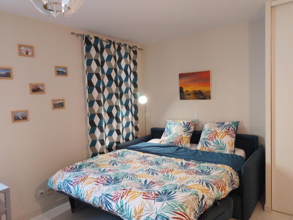 Habitación pequeña con cama y cortina en Les Chatelaines, en Hyères