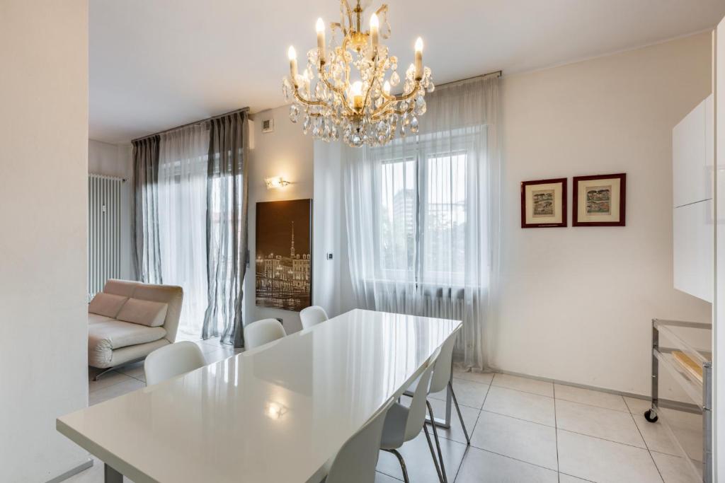 sala de estar con mesa blanca y lámpara de araña en Easylife - Spacious apartment in Maciachini, en Milán