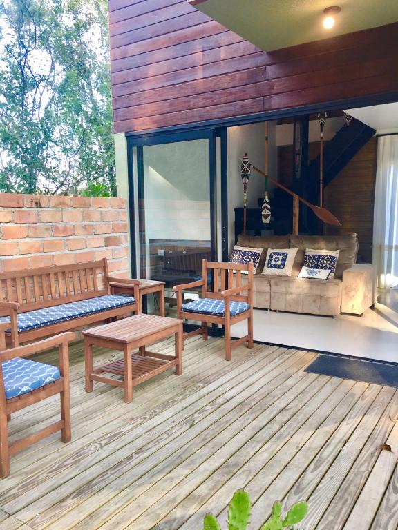 a porch with benches and a couch on a deck at casa natureza Mariscal in Bombinhas