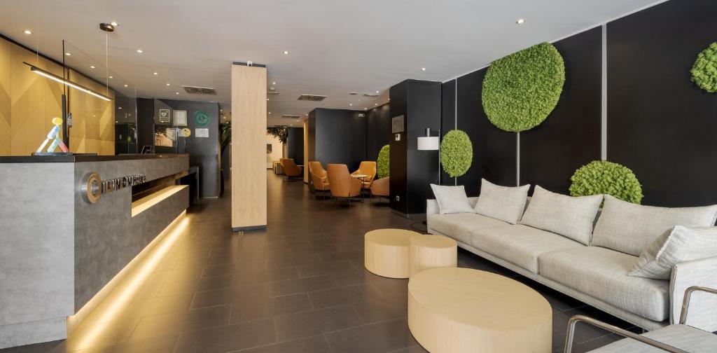 a lobby with a couch and tables and chairs at Ilunion Almirante in Barcelona