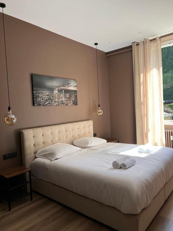- une chambre avec un lit blanc et une fenêtre dans l'établissement LA COSY FACTORY - Centre historique, à Chambéry