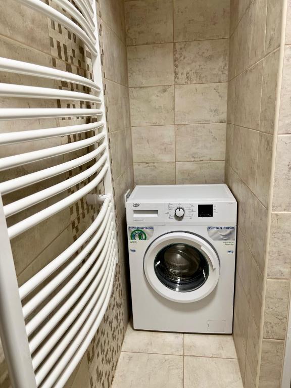 a washer and dryer in a small bathroom at SunSuite Szeged in Szeged