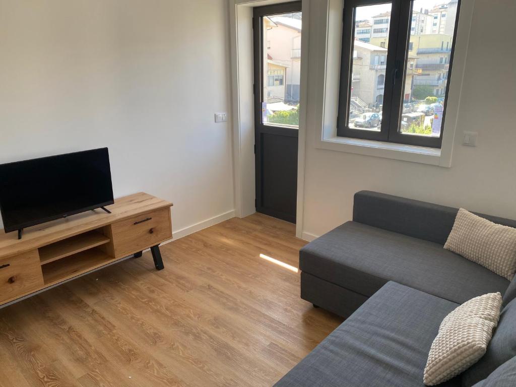 a living room with a couch and a tv at Barros' House in Chaves