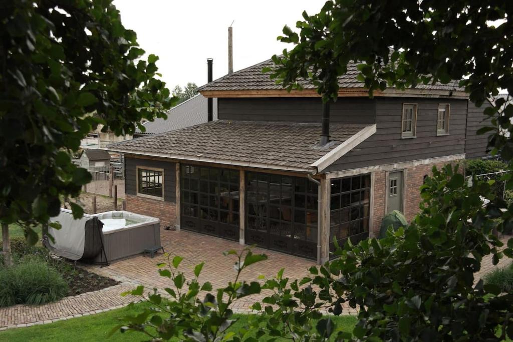ein Haus mit einem großen Gebäude mit einer Garage in der Unterkunft Landgoed Versteegh nabij heerlijkheid Mariënwaerdt in Beesd