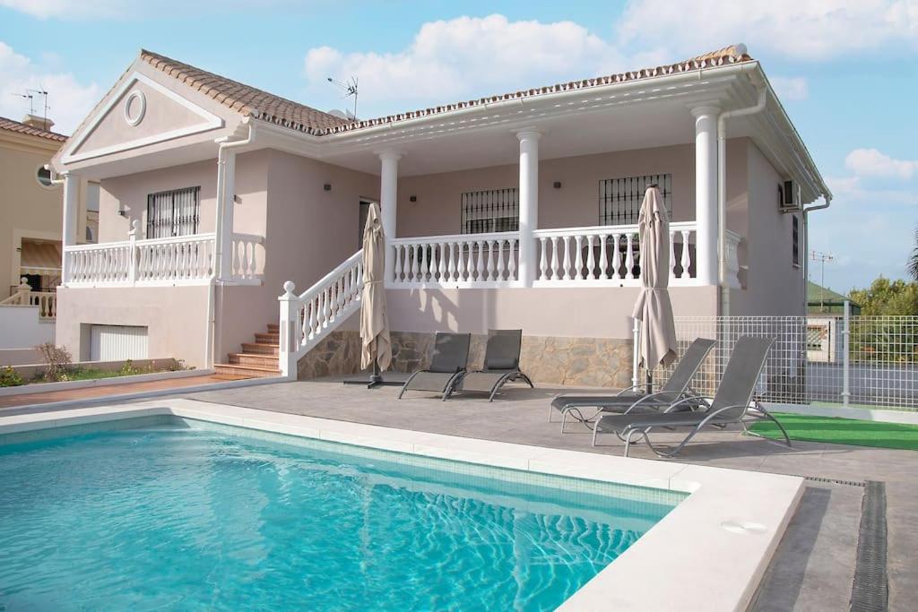 a house with a swimming pool in front of a house at Villa el Olivo in Alhaurín de la Torre