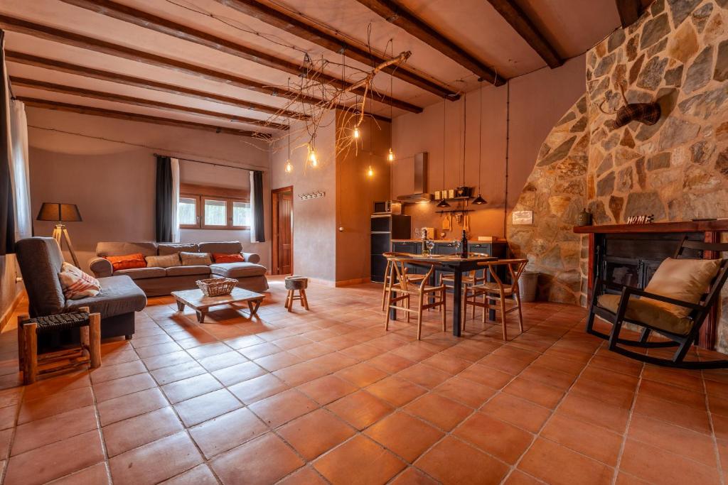 un grand salon avec une cheminée en pierre dans l'établissement Bodega Andrés Iniesta con visita y cata, à Fuentealbilla