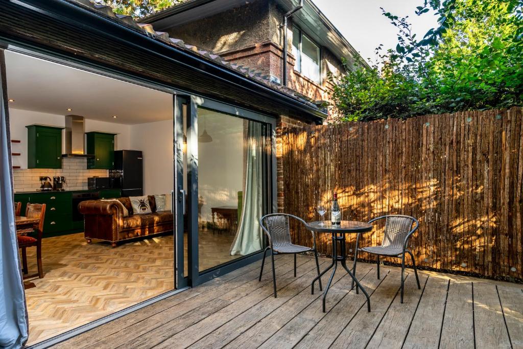 a patio with a table and chairs on a wooden deck at Tawny Lodge in York