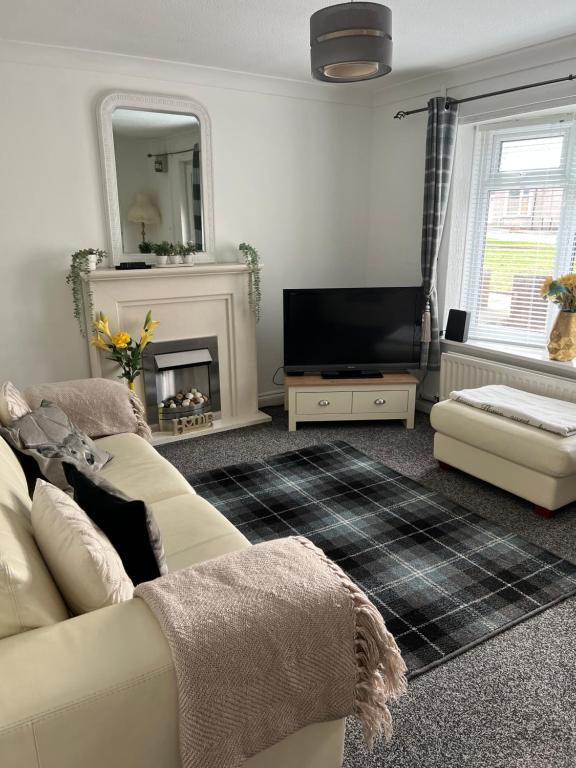 uma sala de estar com um sofá e uma televisão em Normanby Raybould house em Normanby