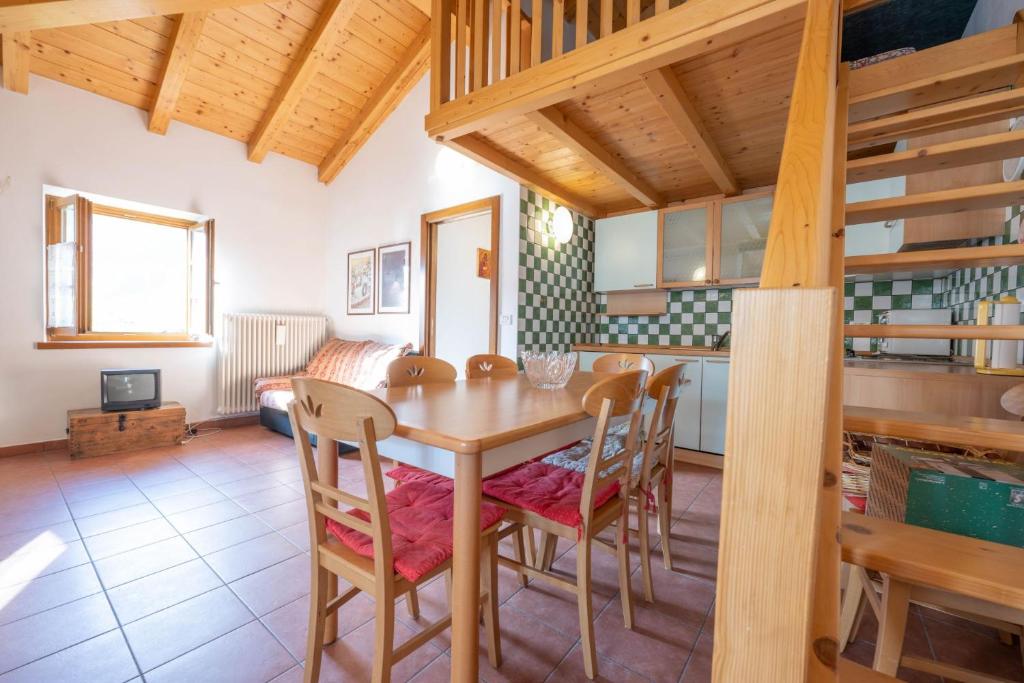 a kitchen and dining room with a wooden table and chairs at Cesa Meida 3 in Pozza di Fassa