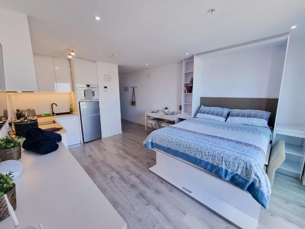 Brand New Top Floor Studio - The Hub Gibraltar - Self Catering في جبل طارق: غرفة نوم كبيرة مع سرير ومطبخ