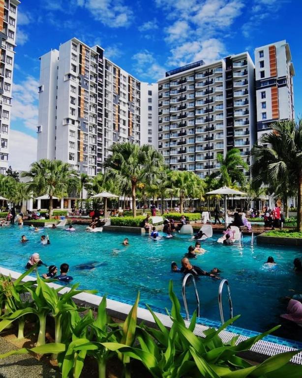 a pool at a resort with people in the water at Timurbay Seafront Seaview & Poolview Suite with Wi-Fi in Kuantan