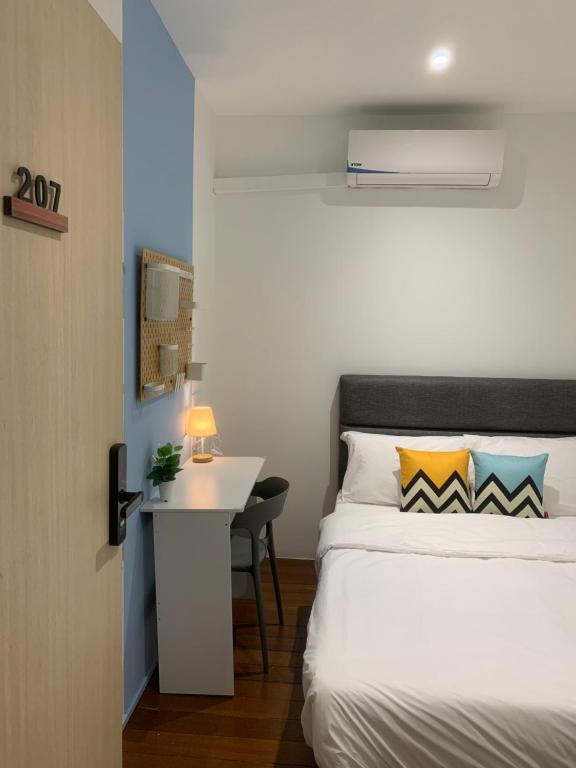 a bedroom with a bed and a desk with a table at Swing & Pillows @ Beach Street in George Town