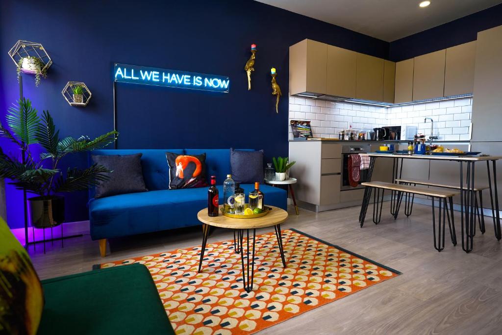 a living room with a blue couch and a table at Luxury Stevenage Town Centre Apartment in Stevenage