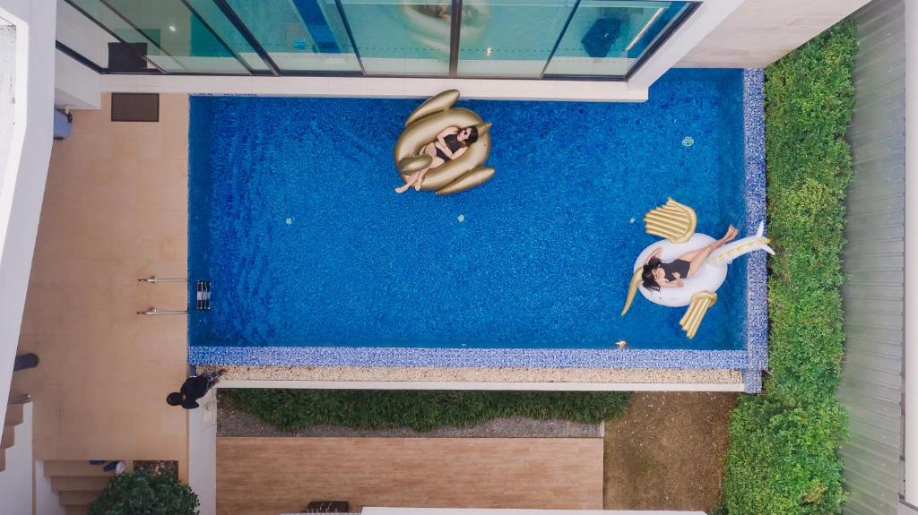 a painting of two people swimming in a pool at Movenpick Pool Villa by Hello Pattaya in Na Jomtien