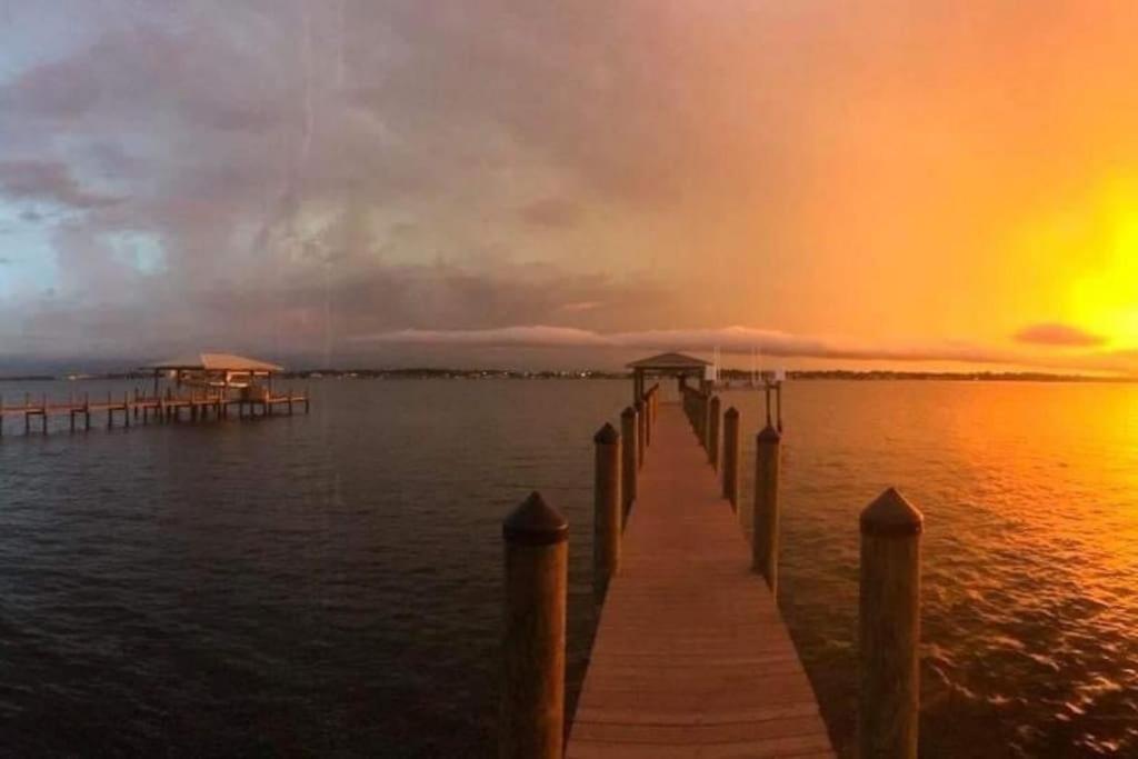a dock on the water with a rainbow in the sky at Happys Camper in the Sunshine in Daytona Beach