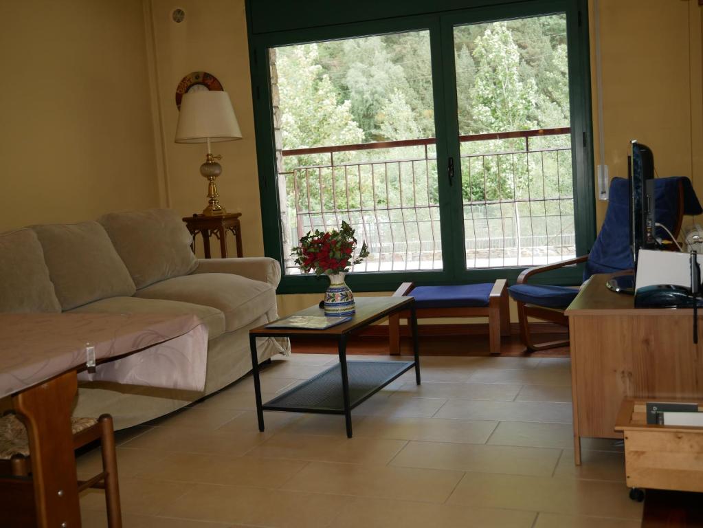 een woonkamer met een bank en een tafel bij Comapedrosa-Vacances Pirinenca in Canillo