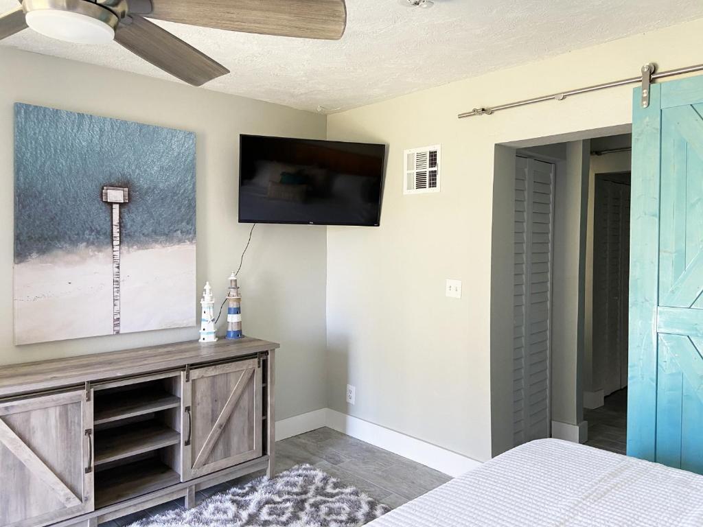 a bedroom with a flat screen tv on a wall at The Blue Anchor Cottage in Daytona Beach