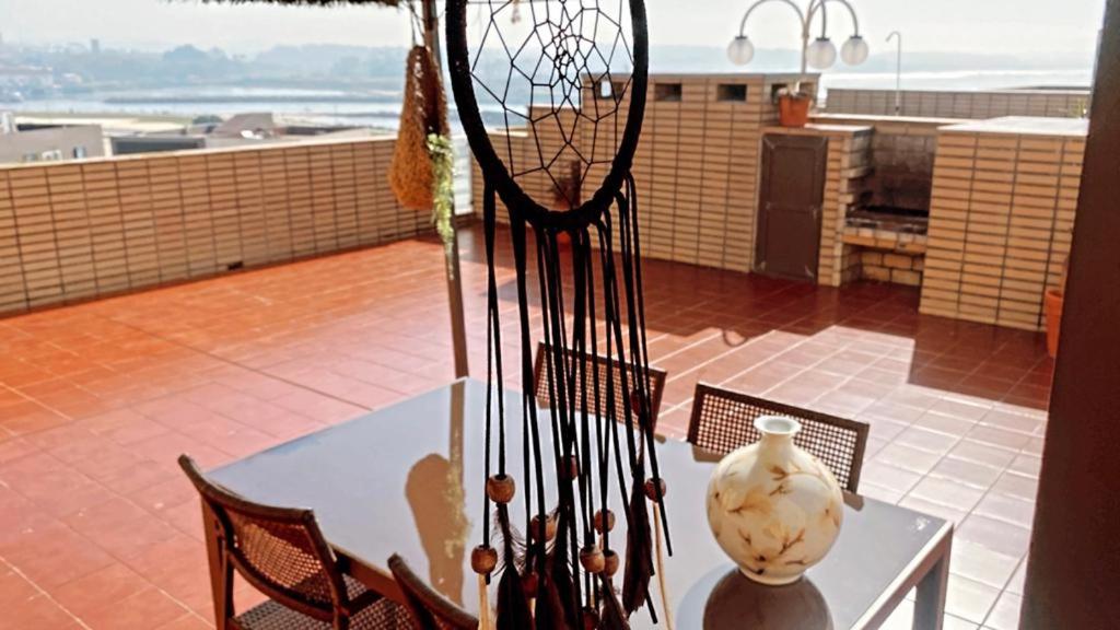 a table and chairs with a vase on a balcony at Apartamento Ruy Belo - Foz in Vila do Conde