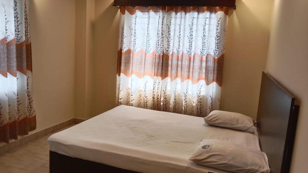 ein kleines Schlafzimmer mit einem Bett und einem Fenster in der Unterkunft Hotel The Grand Sandy in Cox's Bazar