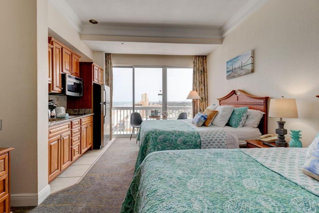 a hotel room with two beds and a balcony at Driftwood Dreams at the Beach in Daytona Beach
