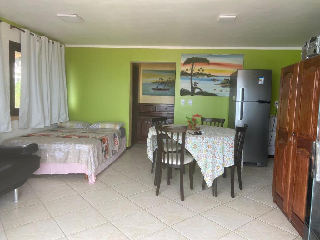 Habitación con 2 camas, mesa y nevera. en Apartamentos Ponta do Sol, en Natal