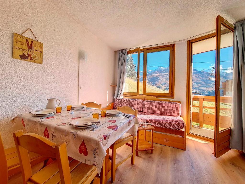 une salle à manger avec une table et des chaises et une fenêtre dans l'établissement Spacieux appart 2 pièces - skis aux pieds - balcon sud - proche commerces - parking dispo - FR-1-344-1048, aux Menuires
