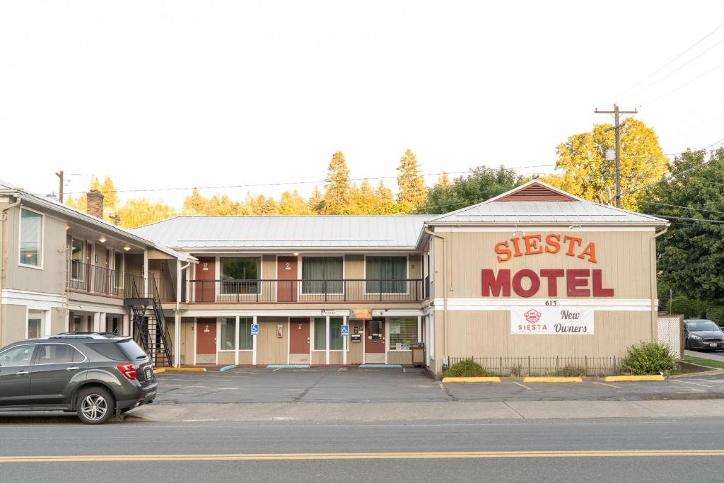 a motel with a car parked in a parking lot at Siesta Motel Colfax WA in Colfax
