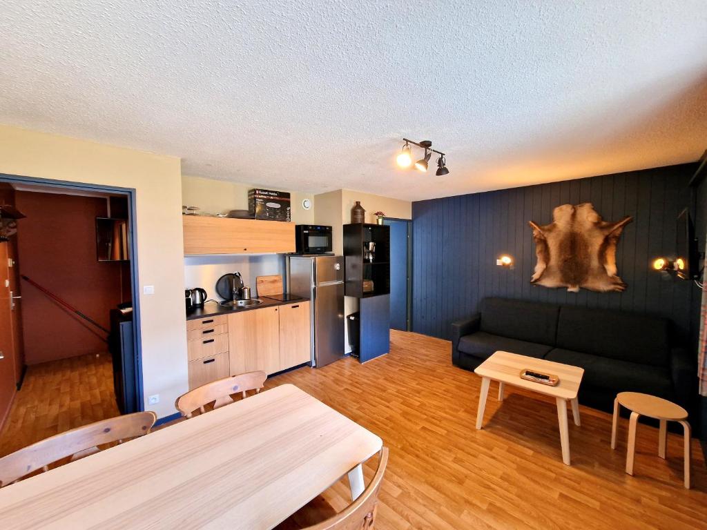 sala de estar con sofá y mesa en Val Louron Hautes Pyrénées Superbe appartement tout confort au pied des pistes 4 personnes en Val Louron