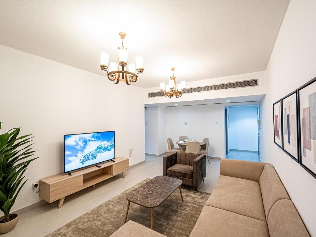 a living room with a couch and a tv at Noble looking 2 Bed only five minutes to Metro in Dubai