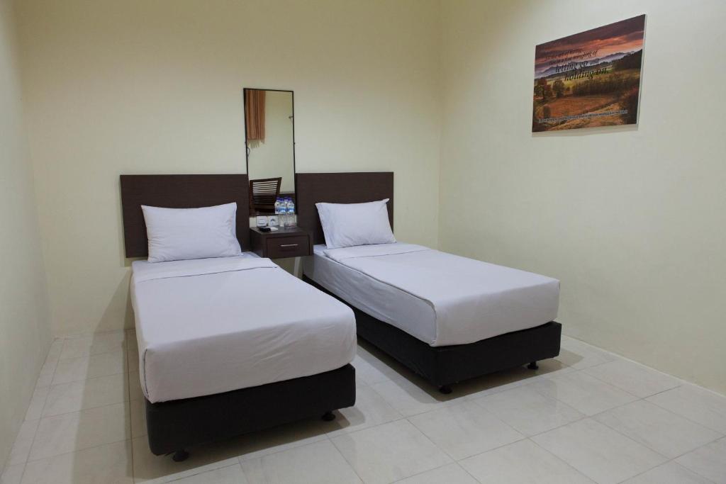 Postel nebo postele na pokoji v ubytování Mahkota Hotel