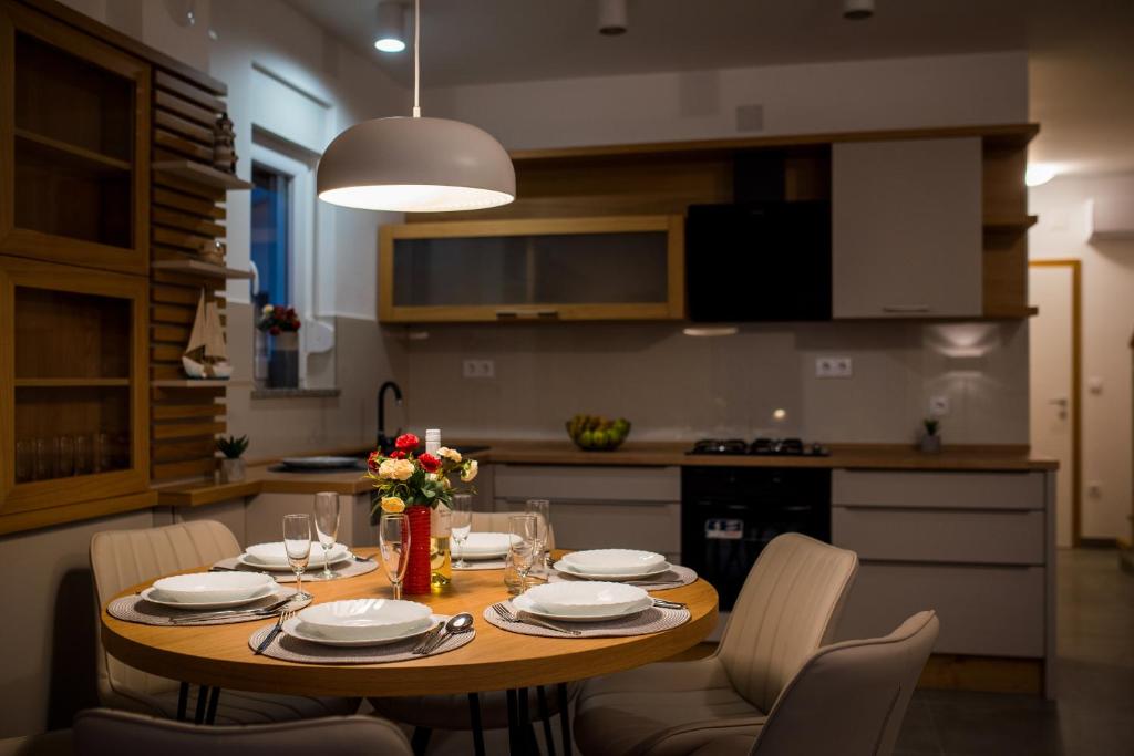 a kitchen with a wooden table with chairs and a dining room at Holiday house Mareta - outdoor swimming pool, 4 bedrooms, WIFI in Jadrija