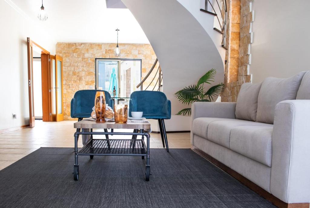 a living room with a couch and a table at English house in Ponta Delgada