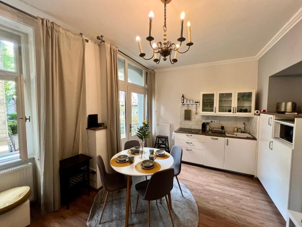 cocina y comedor con mesa y sillas en Adorable, cosy apartment at the Heroes' Square Budapest, en Budapest