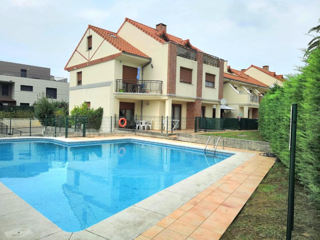 a swimming pool in front of a house at La Arena in Miengo