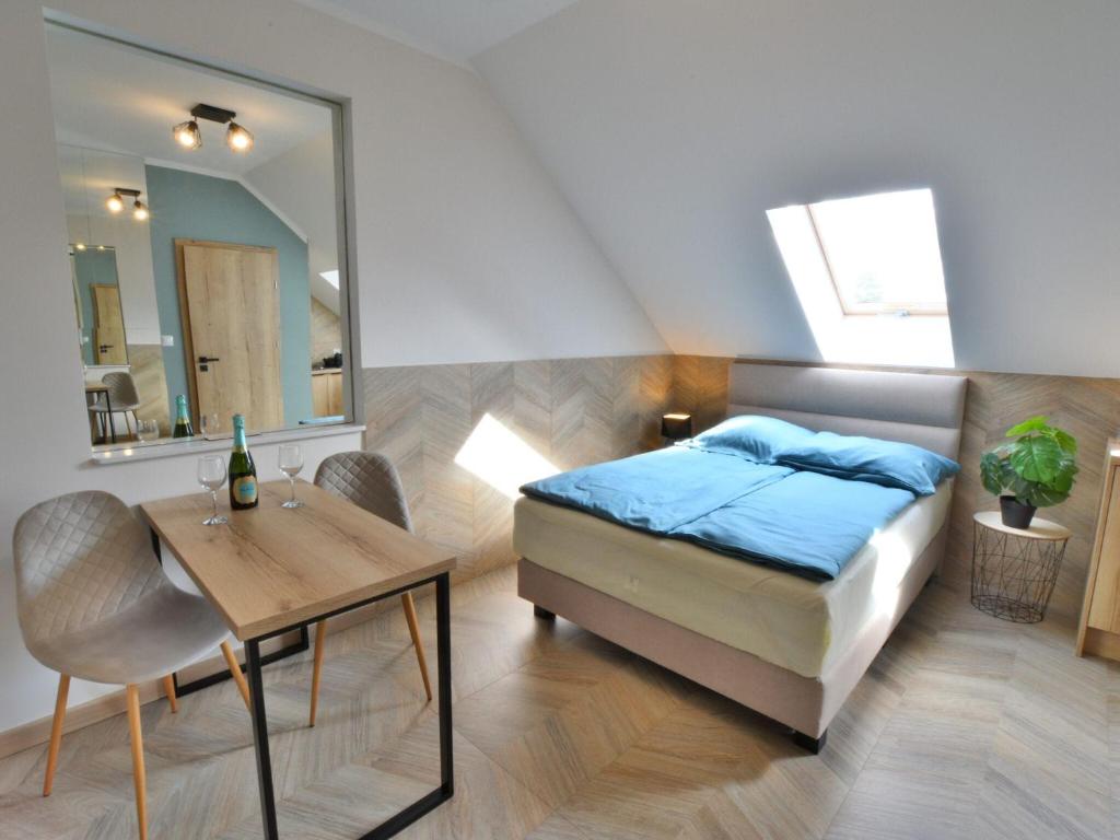 1 dormitorio con cama, mesa y espejo en Comfortable apartment for 2 persons directly by the sea, Ustronie Morskie, en Ustronie Morskie