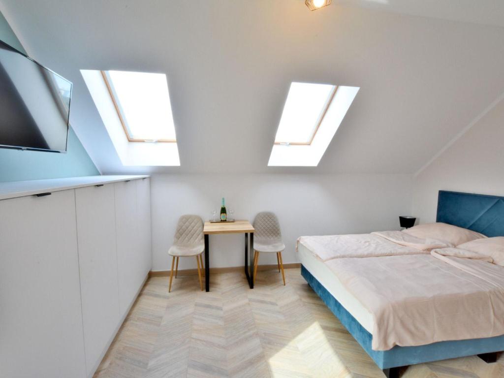 a bedroom with a bed and a table and skylights at Apartment for 2 persons right by the sea, Ustronie Morskie in Ustronie Morskie