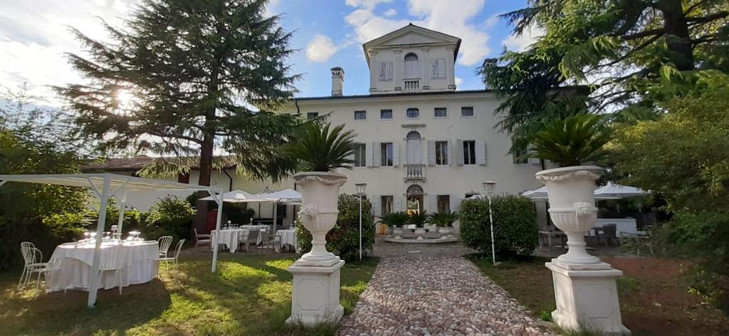 a white house with tables and chairs in front of it at Villa Cigolotti in Vivaro