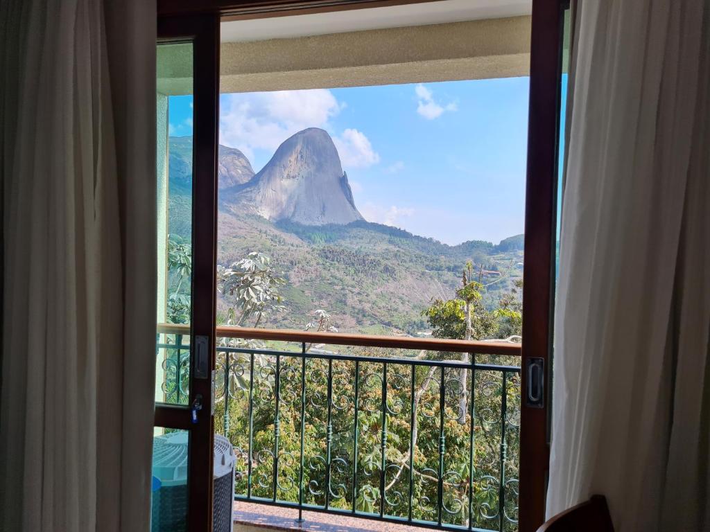 um quarto com vista para uma montanha a partir de uma varanda em Vista para Pedra Azul e TV de 85'' em Pedra Azul
