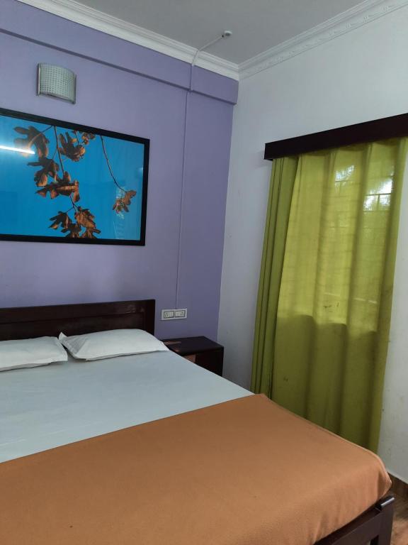 a bedroom with a bed and a fish painting on the wall at Cherry blossom guest house in Arpora