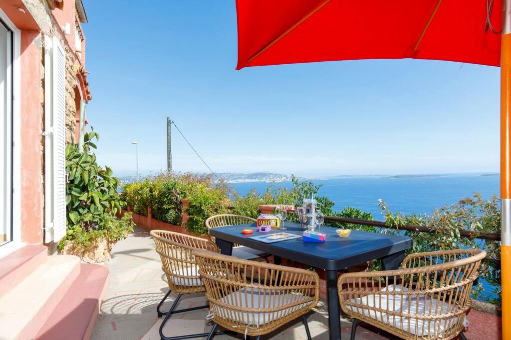 una mesa y sillas en un patio con vistas al océano en Les Oules Vertes YourHostHelper classé 3 étoiles en Théoule-sur-Mer