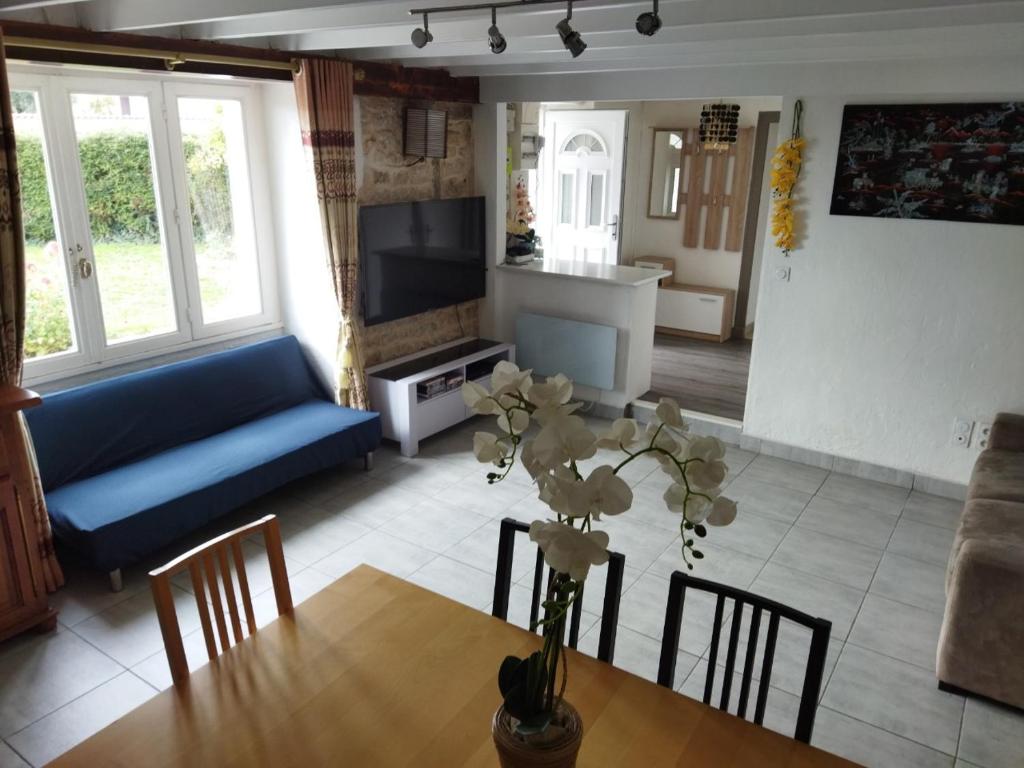 a living room with a table and a blue couch at Charmante maison in Saint-Michel-le-Cloucq