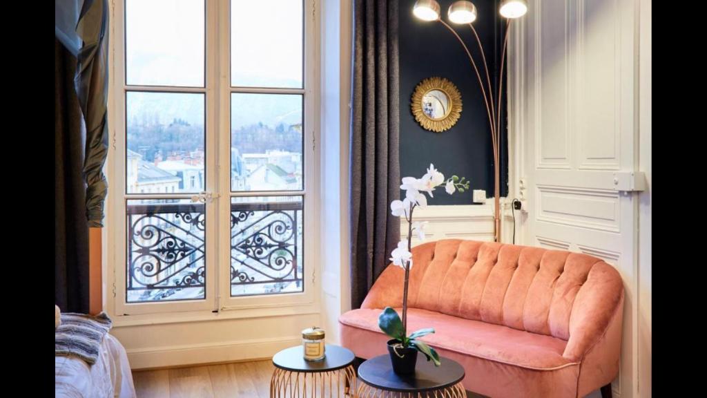 een oranje stoel in een woonkamer met een raam bij Le Gatsby 3 étoiles in Aix-les-Bains