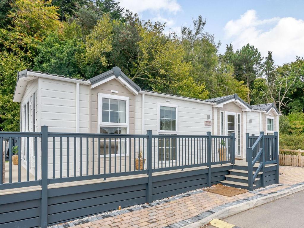 una pequeña casa blanca con una valla azul en European Lodge - Uk40848 en Scarborough