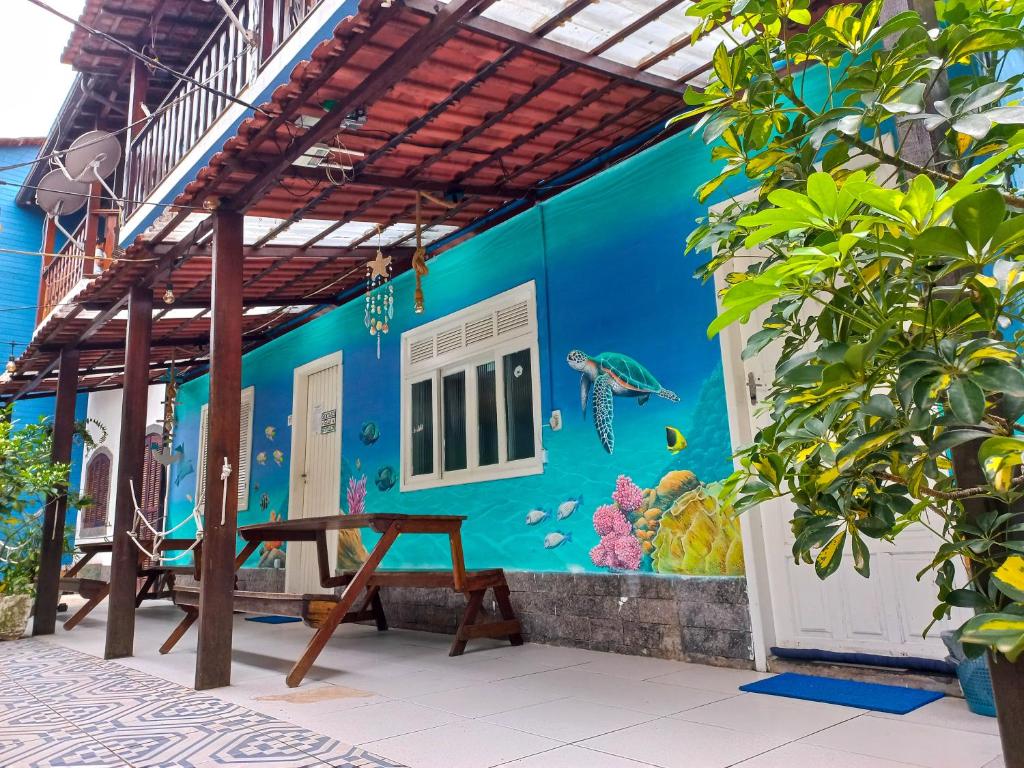 una casa con una pared azul con un mural de pescado en Hostel Blue Lagoon, en Abraão