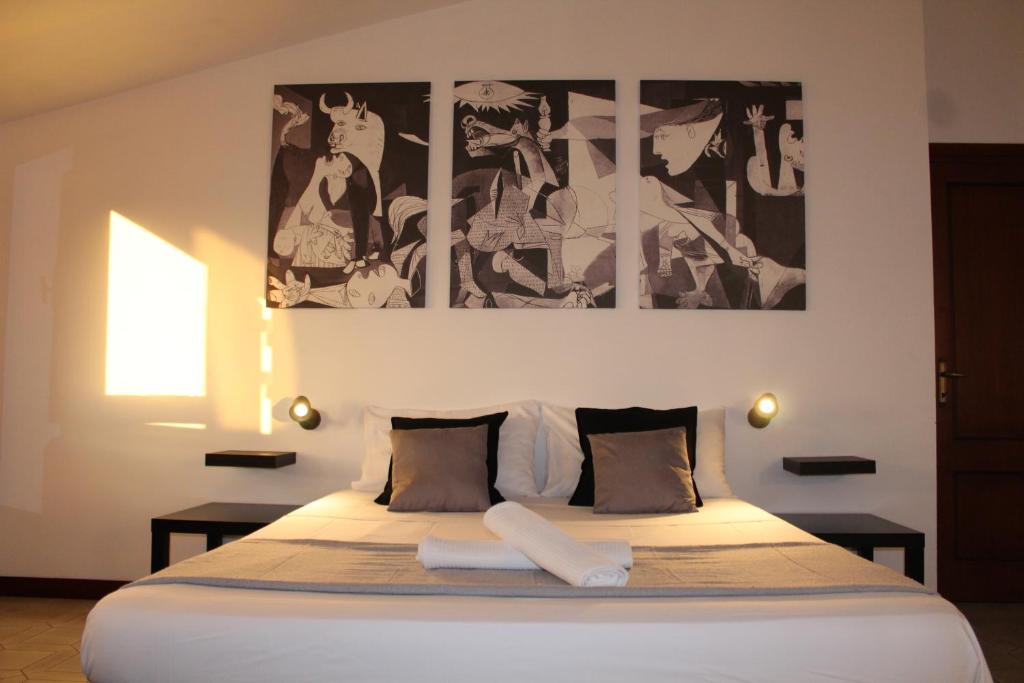 1 dormitorio con 1 cama grande y 3 cuadros en la pared en Confortevole appartamento a Roma FREE PARKING, en Castel di Leva